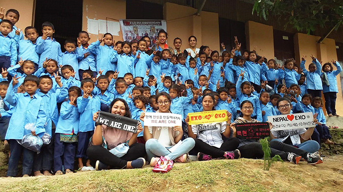  
Members of Nepal's K-pop fan club Exo-L pose for a photo with students at the Koshrang Asdharbhut Vidhyalaya school. (Exo-L Nepal)
